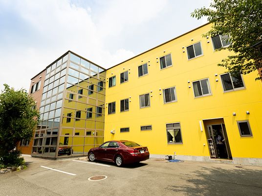 黄色い外壁の建物外観