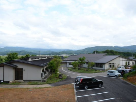 山並みを背景にした外観