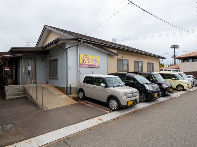 外観と駐車場の外景 外観 親しみやすい外観の建物前には、職員や訪問者のための駐車スペースが整備されています。