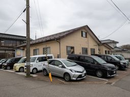 施設と車両が並ぶ外観