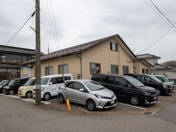 施設と車両が並ぶ外観
