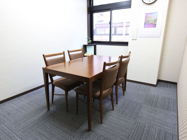 快適な居室の一角 談話室 窓際のテーブルセットが置かれた落ち着いた雰囲気の部屋です。自然光を浴びながら、ゆったりとした時間を過ごすことができます。