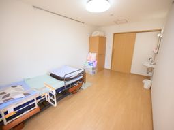 明るい居室のベッドと洗面台