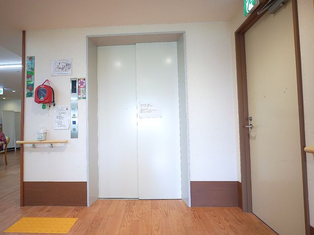 エレベーター前の廊下 エレベーター 広々とした廊下に面したエレベーター前の空間です。周囲は落ち着いた色合いで、清潔感が感じられます。