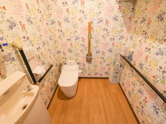 花柄の壁紙が印象的なトイレ