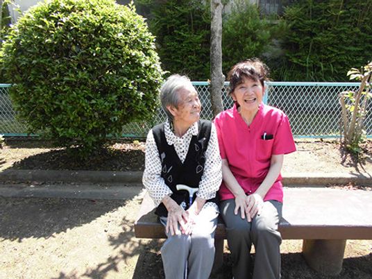 中庭にて笑顔のご利用者と職員