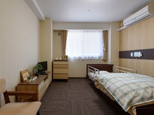 介護用ベッドとタンス類が並べられている施設内の居室の写真。コーディネート例