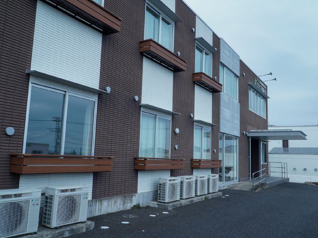 外壁がモダンな建物外観 外観 清潔感のある外壁と落ち着いた色合いが特徴の建物です。就労を検討されている方には、心地よい職場環境を提供しています。