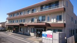 明るい日差しの3階建て外観