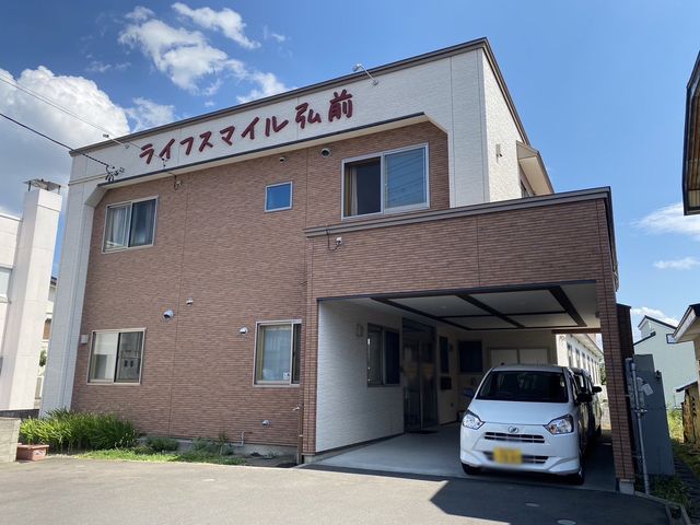 看板付き外観 外観 広々とした駐車スペースのある建物です。車でのアクセスが便利な環境です。