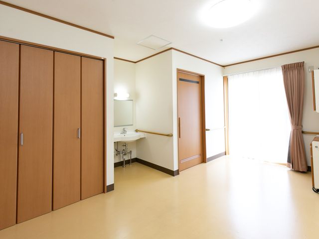 広々とした明るい居室 居室 手すりが設置された広々とした居室は、日当たりが良く快適な空間です。ゆったりとお過ごしいただける環境が整っています。