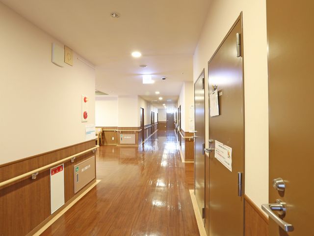 清潔な廊下の様子 廊下 手すり付きで安全性が高く、ツヤのある床が気持ちいい廊下です。働くスタッフの動線も考えられています。