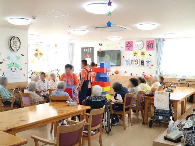 明るい共有食堂 リビング 手作りの飾りが並ぶアットホームな食堂で、利用者が笑顔で交流できる温かい環境です。ここでの時間を通じ、楽しみながら食事をいただけます。