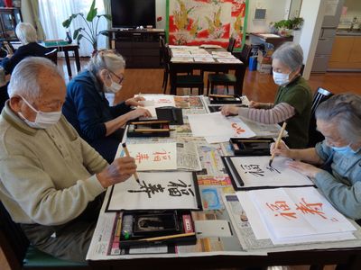 書道指導をする高齢者の姿