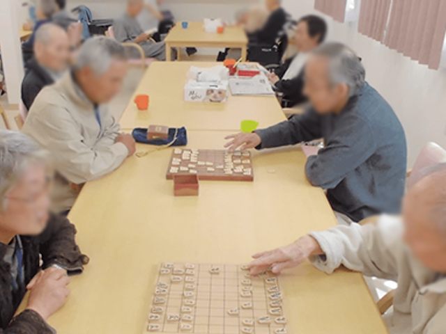 将棋を楽しむ光景 ラウンジ 明るいスペースで、テーブルを囲んで将棋を楽しむ様子。くつろぎながら交流もできます。