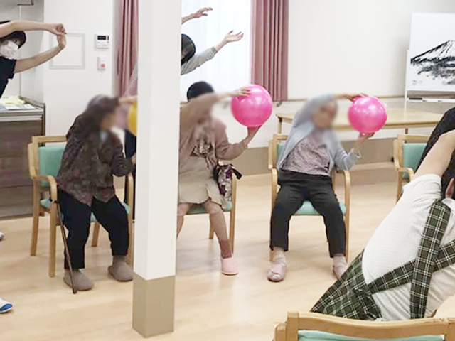 体操する人々の室内 機能訓練室 明るい空間の中で、楽しく体を動かすことができる場所です。快適な雰囲気でリラックスできます。