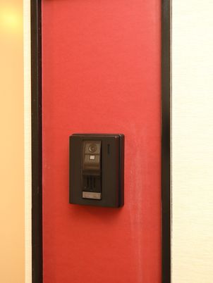 赤い壁に付くインターホン