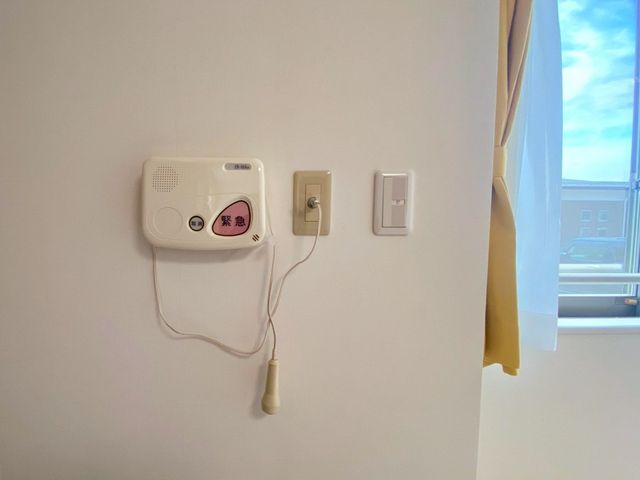 緊急呼出しボタン　居室 居室 居室には緊急呼出しボタンが設置されていますので、安心して就業できる環境です。窓からは自然光が差し込み、明るい空間です。