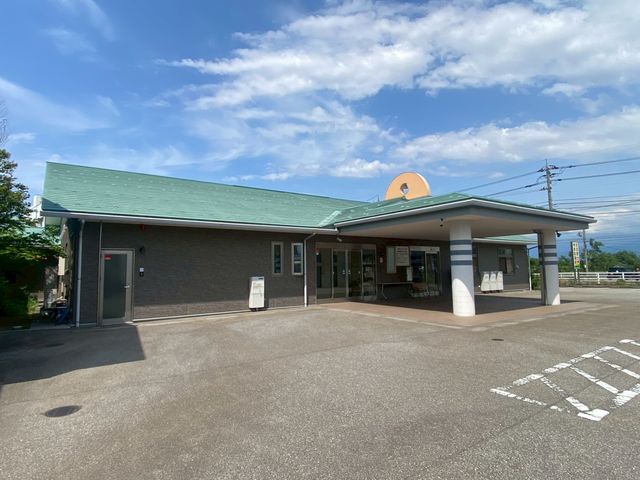 青空と広々とした建物 外観 緑の屋根が特徴的な施設の入口が広く取られており、アクセスがしやすいです。