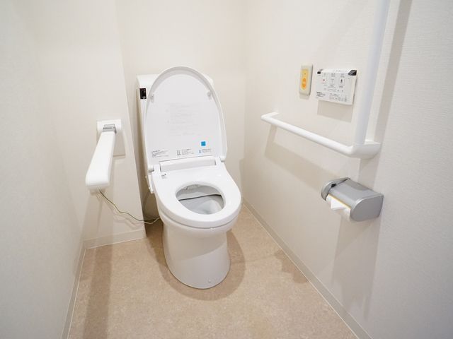 バリアフリートイレの内観 トイレ 手すりが設置された広々としたトイレは、安全で快適な利用を支えています。利用者のことを考えた設計が行き届いており、安心してご就業いただける環境です。