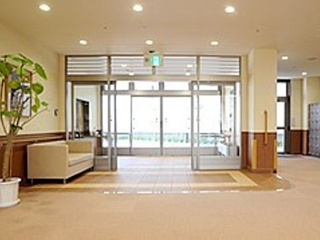 広々とした明るいエントランス エントランス 広々としたエントランスでは、温かな光が差し込み、訪れる人を優しく迎え入れてくれます。手すりが整備されていて安全に配慮された空間です。