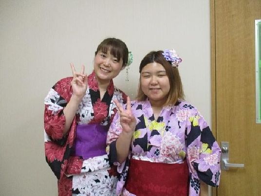 浴衣姿の女性2人が並ぶ室内  