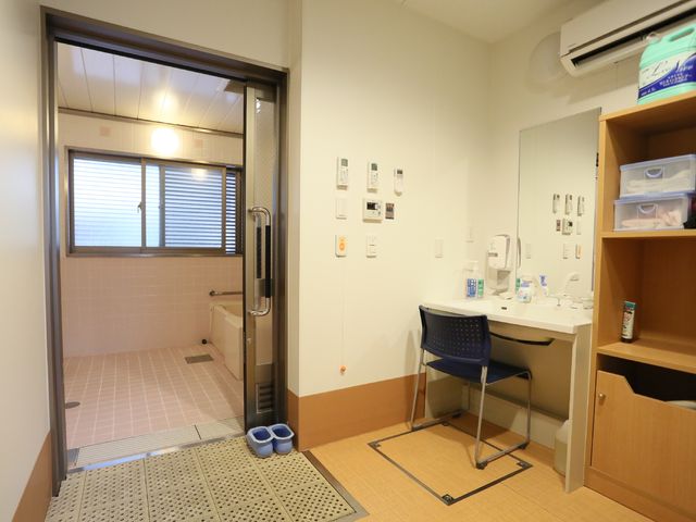 明るい清潔な浴室入口 脱衣所 広々とした清潔感のあふれる洗面台と浴室への入口があり、安心してご利用いただける環境です。機能性を重視した設計で、日々の快適さを支えます。
