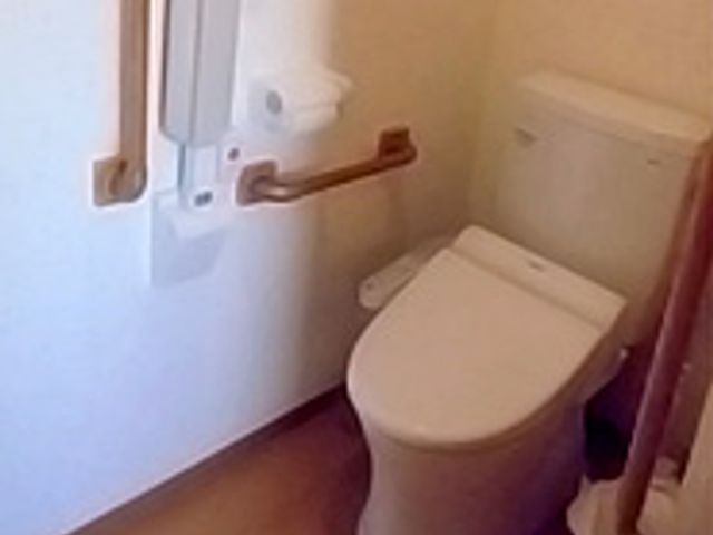 手すり付きのトイレ トイレ   手すりが設置されたトイレです。安全性が考慮されており、安心して利用できます。