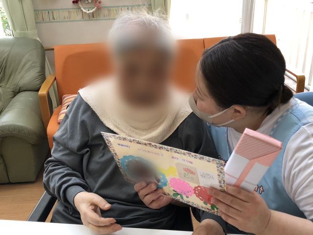 居室での会話 居室 スタッフと入居者が親しげに会話を交わしています。心地よい雰囲気が感じられます。