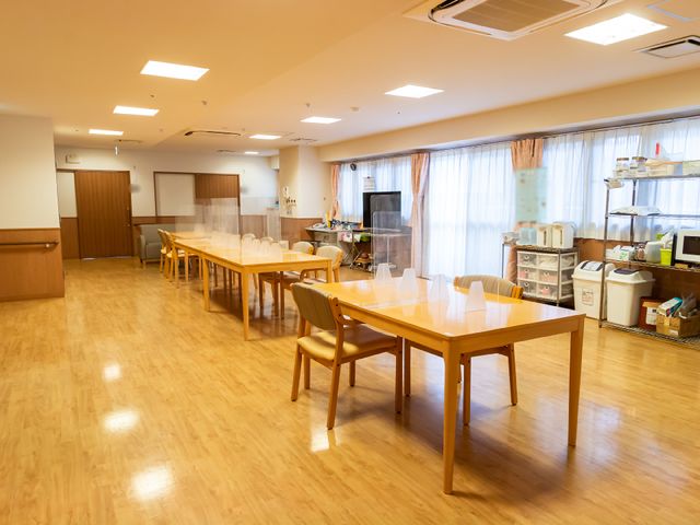 広々としたダイニングスペース 共有スペース 明るく開放感のある食堂で、ご利用の方々が食事を楽しんでいます。車椅子の方も安心して使える広さが確保されています。