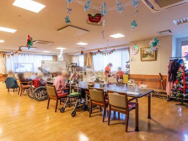 クリスマス飾りのある居室 共有スペース 季節感溢れる装飾が施された居心地の良い空間で、共に食事を楽しむ姿が見受けられます。お仕事中の潤いを感じられる、明るく開放的な環境です。
