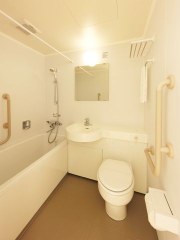 バリアフリー設計のトイレ 浴室 手すり付きで安全に配慮されたトイレスペースです。広々としたデザインは利用者の快適さを考えたものになっています。