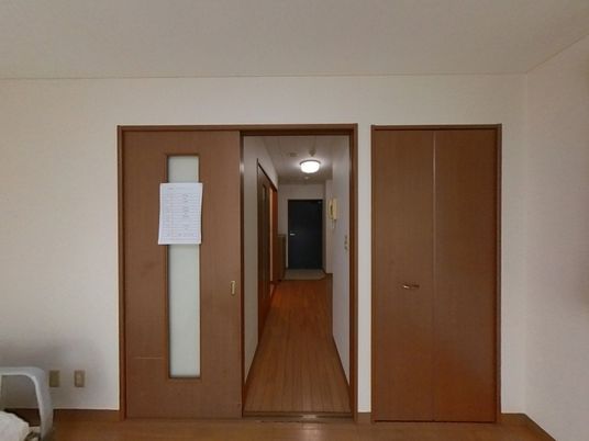 白い壁と木製ドアの廊下