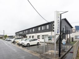 白い車が並ぶ建物