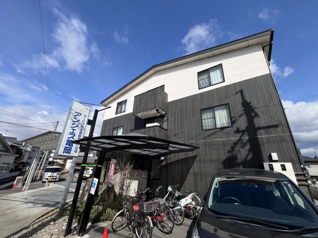 自転車置き場付き建物外部 外観 施設の外観には複数の窓があり、駐車スペースと自転車置き場を完備しています。
