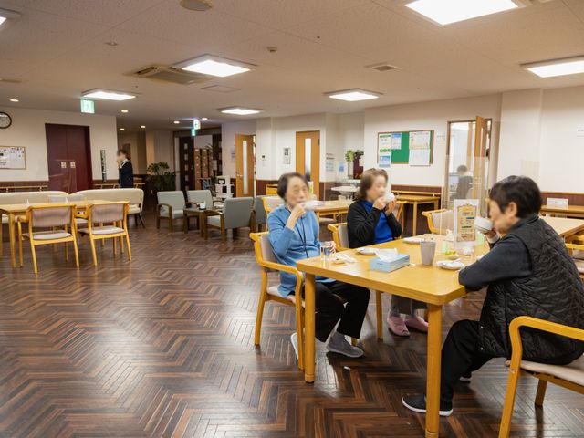 広々とした空間の食堂 ダイニングルーム 広々としたダイニングルームで、自然光が差し込む明るい空間となっています。お食事を楽しむ方々の姿も見られる、落ち着いた雰囲気です。