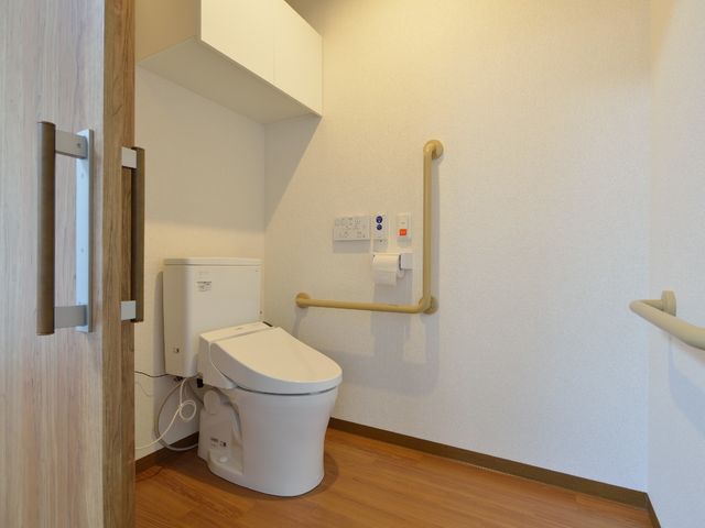 バリアフリー設計のトイレ トイレ 安全に配慮した手すり付きの清潔なトイレです。全ての方が安心してお使いいただけるよう設計されています。