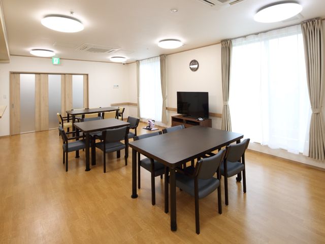 ダイニングルームの風景 リビング 落ち着いた色合いのダイニングルームです。共有の食事スペースは、テレビを見ながらゆったりとお食事が楽しめるように配慮されています。