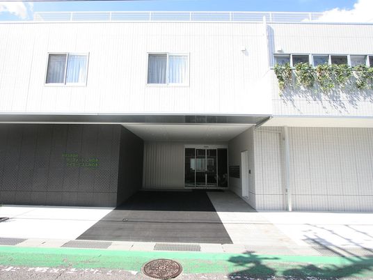 白い外壁の施設入口  