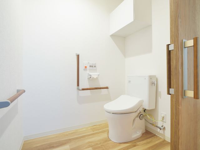 清潔感あるトイレスペース トイレ 安全な手すり付きの明るいトイレは、快適な利用をサポートします。手すりは立ち座りをしっかり支え、安定感を提供します。
