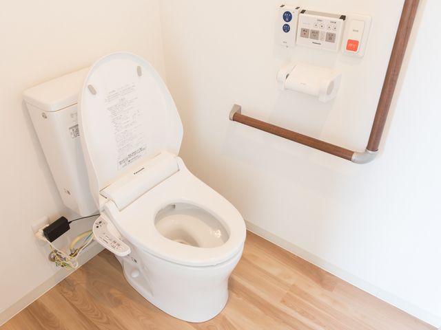 バリアフリートイレ設備 トイレ 安全を考慮した手すり付きの清潔なトイレです。利用者の快適さと自立を支援するための工夫が見られます。