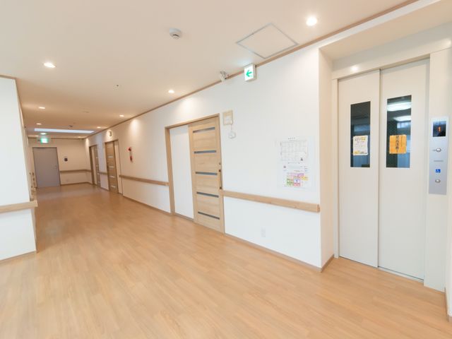 広々とした明るい廊下 廊下 モダンで清潔感あふれる廊下は、ここで働く皆様の心地良い移動空間を提供しています。木目調の床材が温かみのある雰囲気を演出し、窓からの光が空間を優しく照らします。