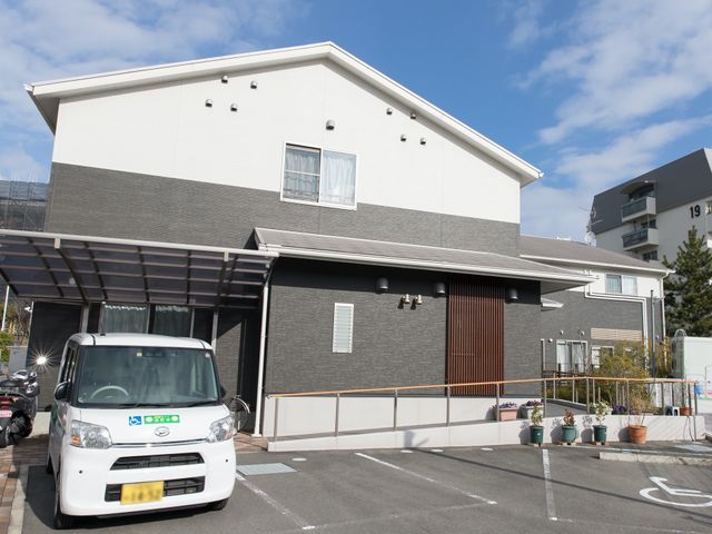 施設の正面外観 外観 清潔感溢れる施設正面で、来訪者を迎える環境が整っています。利用者の移動や安全を考慮した広々とした駐車スペースが確保されています。