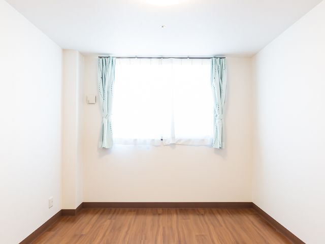 シンプルな洋室の窓辺 居室 清潔感あふれる室内は、落ち着いた色合いでまとめられており、新たな生活を始められる方にとって理想的な空間です。