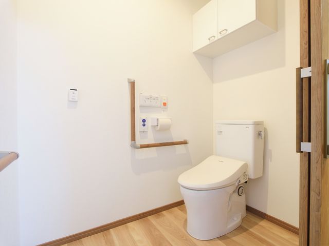 手すり付きの清潔なトイレ トイレ バリアフリー設計の清潔感あふれるトイレが、利用者の安全と快適さを支えます。手すりも設置されており、安心してご利用いただける環境です。