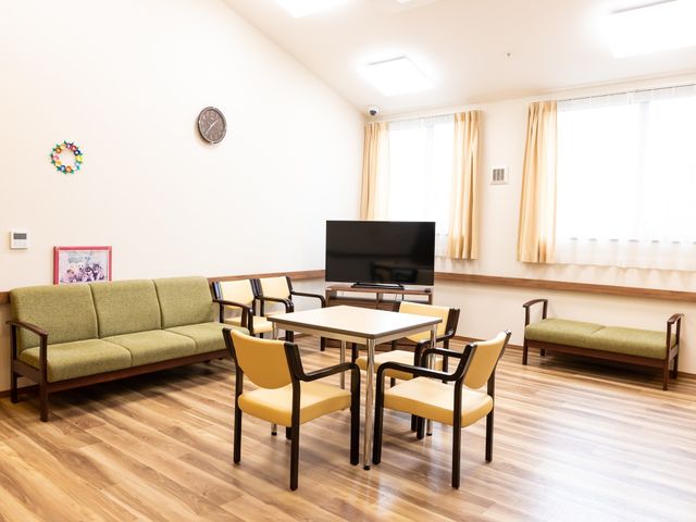 共有ラウンジの空間 談話室 広々としたラウンジでくつろぎながら、大型テレビでの視聴や交流を楽しめる設計です。落ち着いた色合いが温かみを与え、居心地の良い時間を提供します。