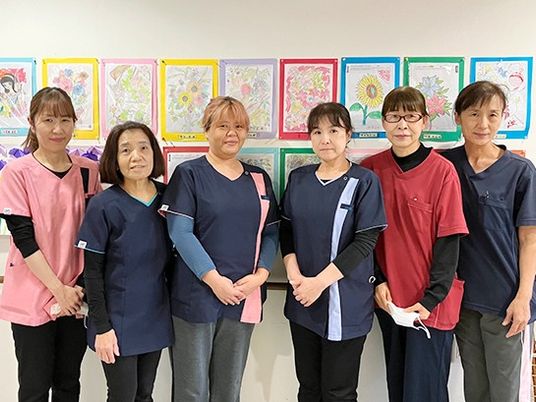 スタッフが並ぶ掲示物前  
