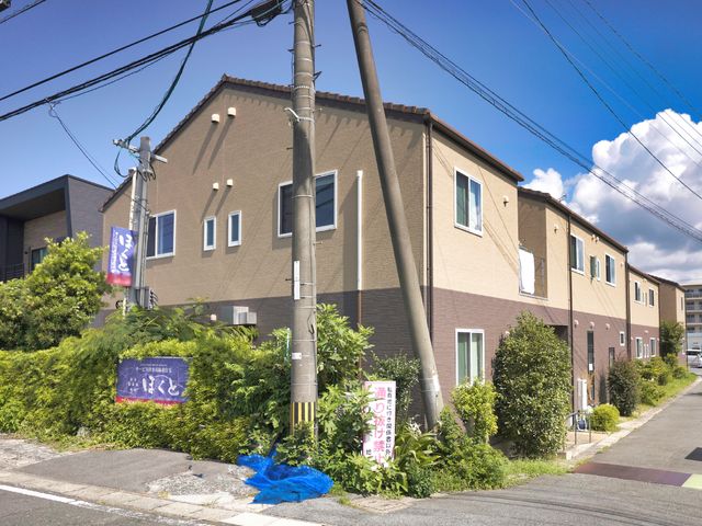 暖色系の外壁の建物 外観 陽当たりの良い日差しが映える施設の外観です。緑に囲まれており、落ち着いた環境でのお仕事をお探しであればぜひご検討ください。
