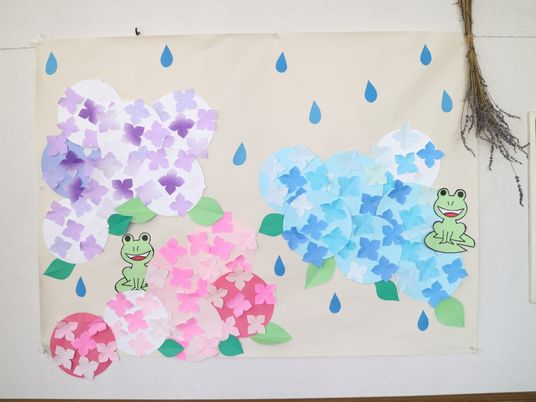 壁に掛けられた花とカエルの飾り