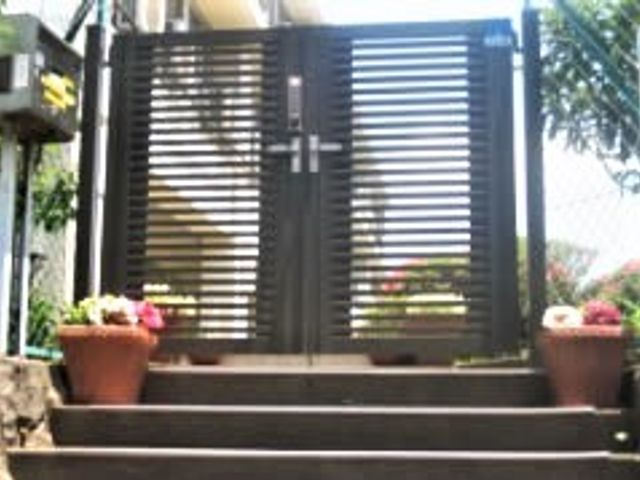 エントランスの門扉前景 エントランス 門扉を彩る鮮やかな花々が迎える、心安らぐエントランスです。ゆとりを感じさせる設計で、お越しになる皆様の第一歩をお手伝いします。